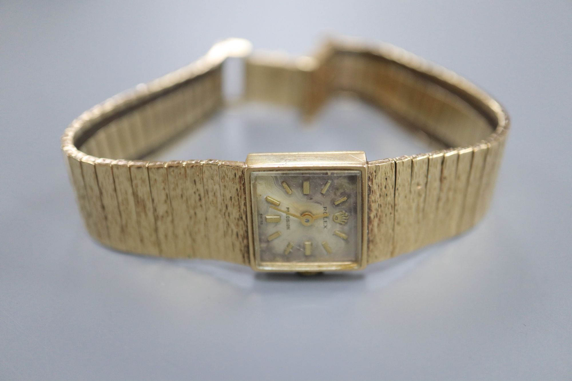 A ladys 9ct gold Rolex Precision manual wind wrist watch, on textured 9ct gold bracelet, dial and glass a.f.